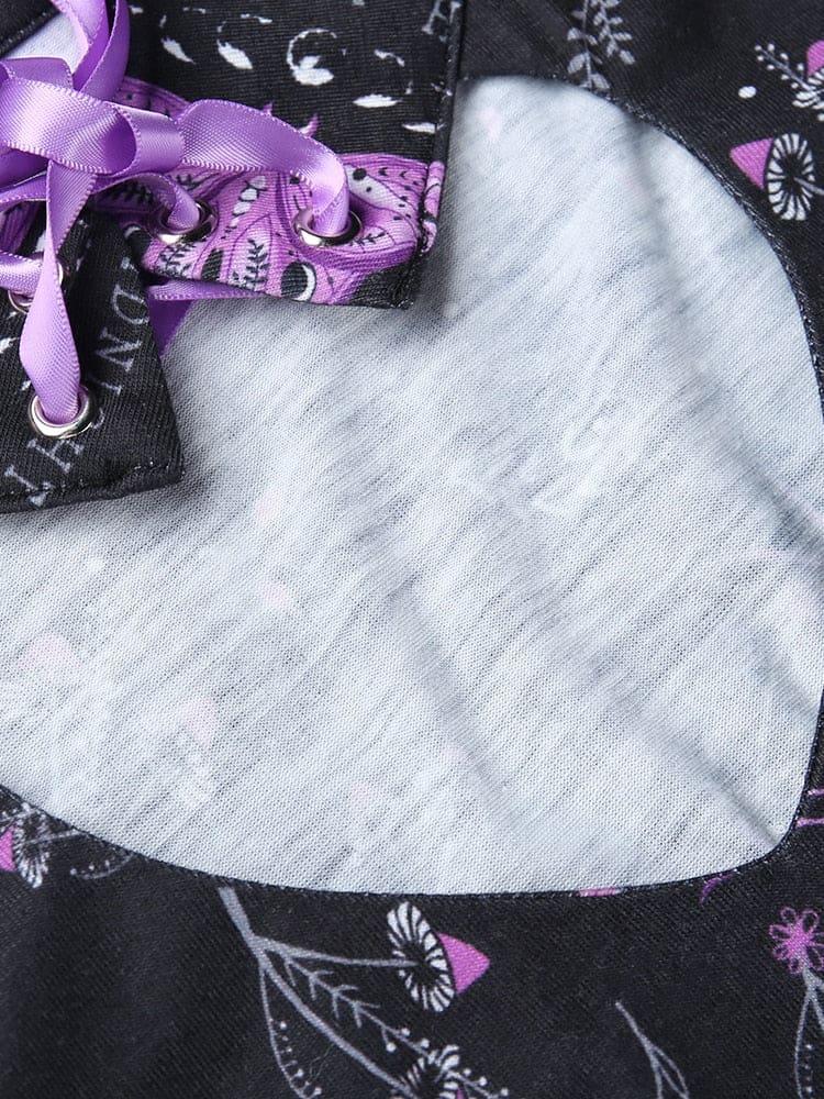 Rounded keyhole cutout of the black purple-moth dress shown flat on a pale surface, with the ribbon-laced collar visible at the top.