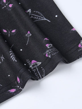 Short sleeve of the black moth dress shown flat, with a stitched cuff edge and small purple mushrooms and botanical motifs.