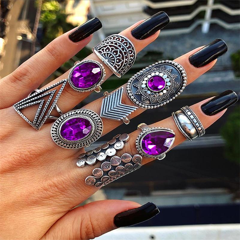Nine-piece silver-tone ring set with purple jewel-like accents worn across fingers to show the mix of large and small designs.