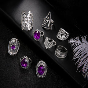 Nine-piece silver-tone ring set with purple jewel-like accents shown with the geometric bands and purple accents on black.