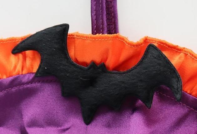 Purple and orange ruffled bat monokini with black bat embellishments, a matching neckband, and narrow side ties