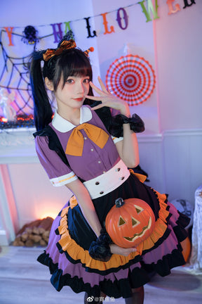 Purple Halloween dress shown from an angle with a pumpkin bucket held in front of the black apron panel and orange ruffle edging.