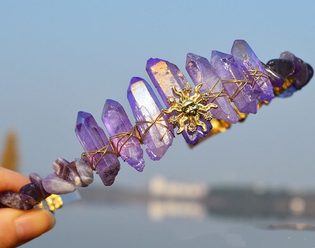 Front view of a purple crystal sun face tiara, with gold-tone rays framed by tall violet points.