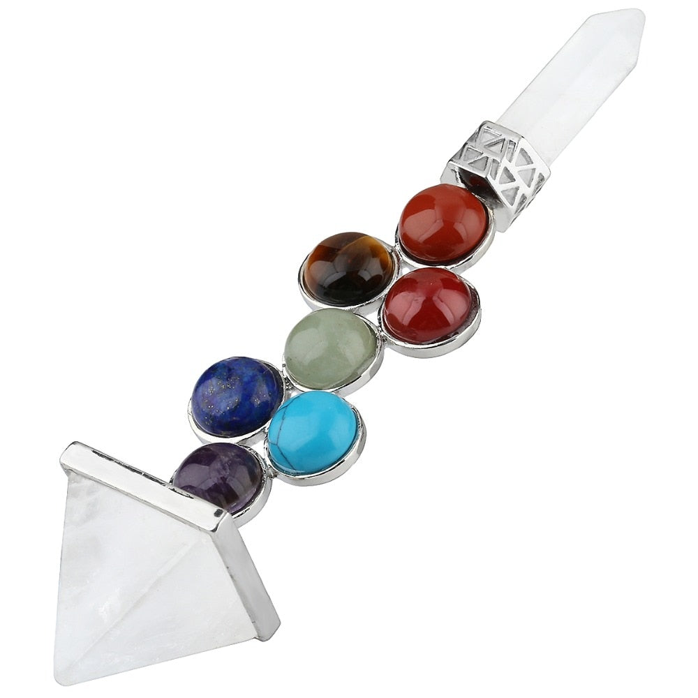 Clear quartz chakra wand angled across white, with a pyramid end, pointed tip and colourful round accents in silver-tone settings.