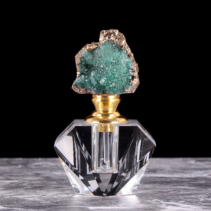 Closer view of the green crystal-topped bottle, showing its faceted clear base and slim dauber inside the neck.