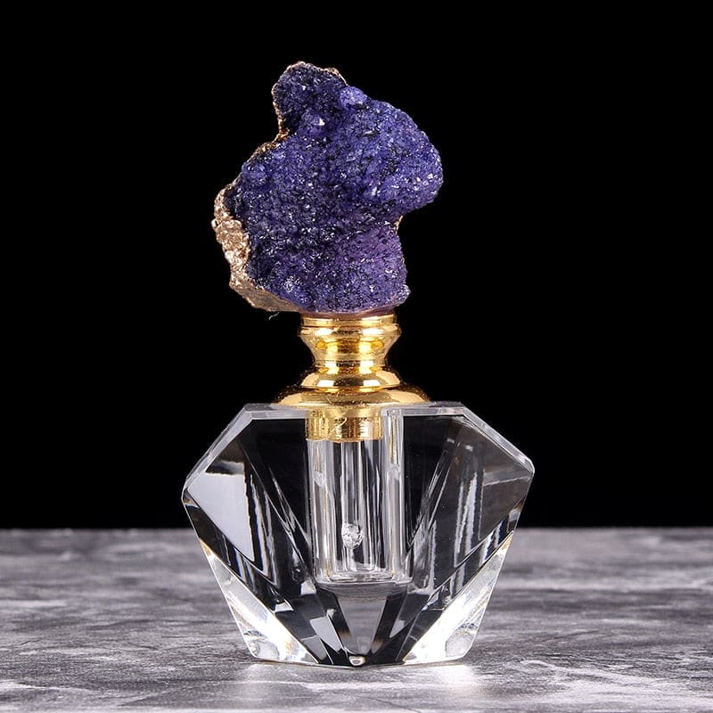 Purple quartz-topped perfume bottle with a gold-tone neck, shown upright against a black background.