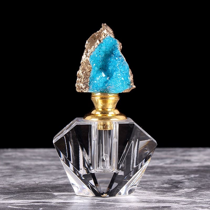 Bright blue crystal-topped perfume bottle, with an irregular cluster stopper above a gold-tone neck and angular clear base.
