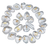 Quartz rune stones arranged in a circle, with clear and milky white polished surfaces and gold-coloured characters. The set includes a blank stone.