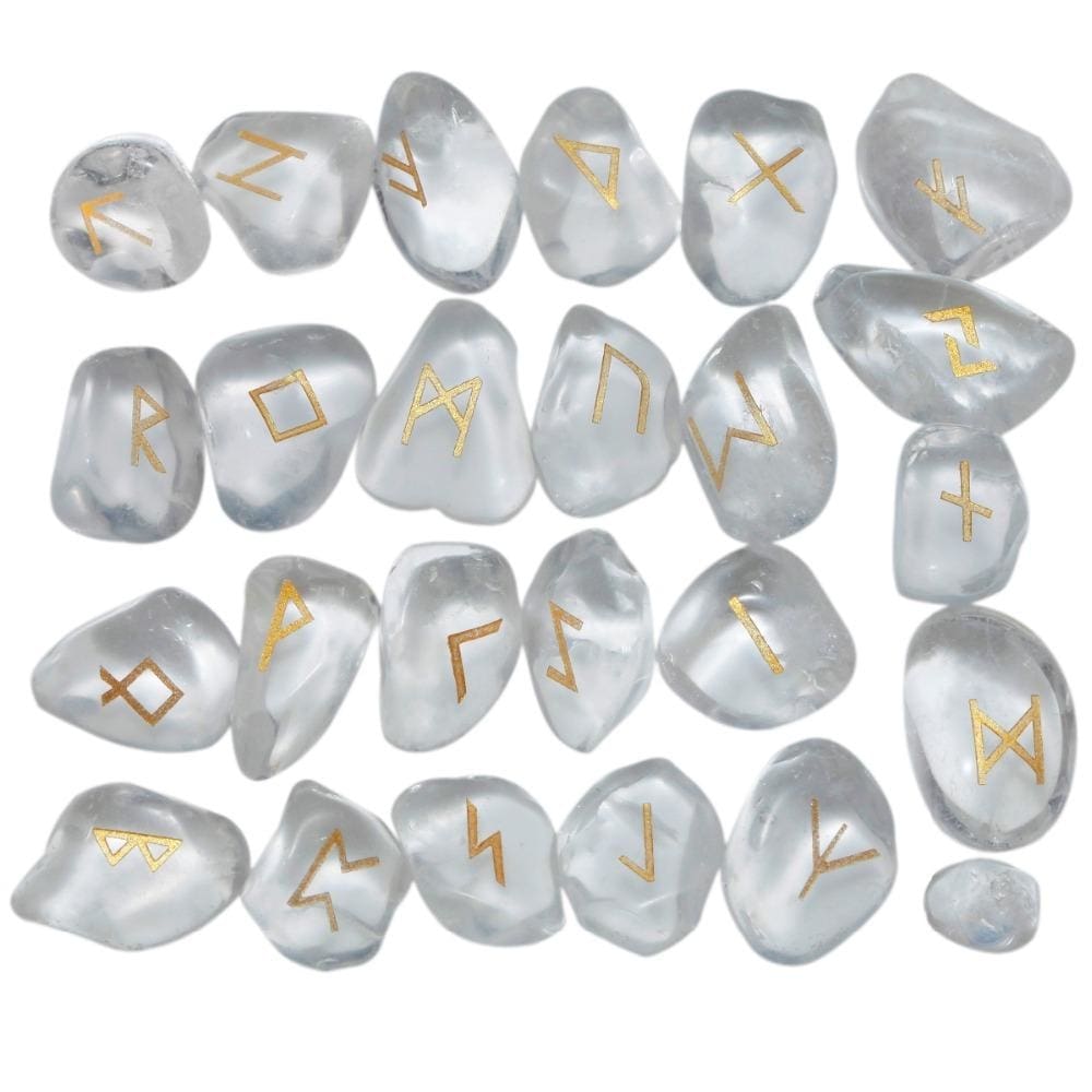 Quartz rune stone set laid out in rows, showing individual gold-coloured characters and one unmarked stone against clear and milky white surfaces.