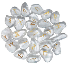 A loose pile of quartz rune stones with clear and milky white surfaces, rounded edges and gold-coloured rune marks visible across the top.