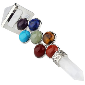 Angled close view of a clear quartz wand, highlighting purple, blue, green, brown and red round accents between its geometric ends.