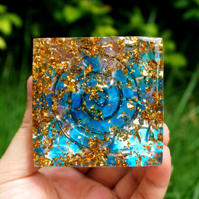 Additional view of Rainbow mandala orgone pyramid with a pale purple sphere, blue stone details and gold-tone flecks. Another underside view shows the blue chips and copper spiral among metallic flecks.