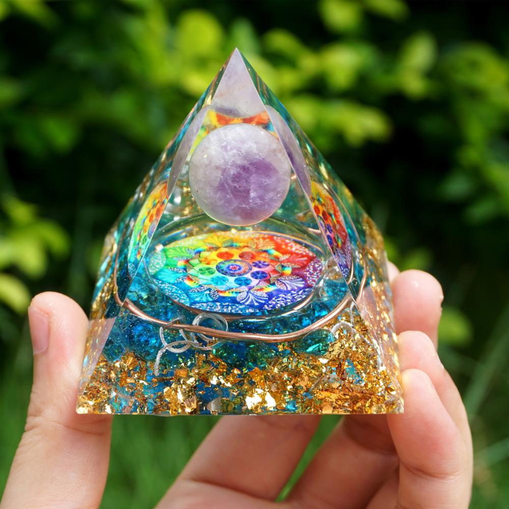 Rainbow mandala orgone pyramid with a pale purple sphere, blue stone details and gold-tone flecks. Full front view held between fingers with blue and metallic layers below the sphere.