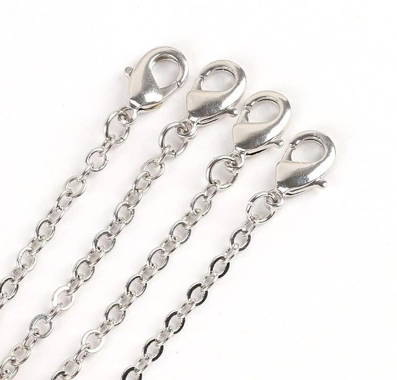 Close view of several silver-tone bracelet chains and their lobster-claw fastenings.