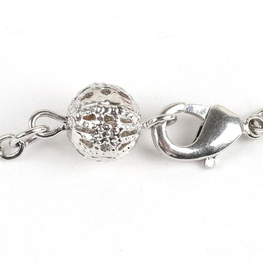 Close-up of the chakra bracelet’s lobster-claw clasp, fine chain and decorative openwork ball.