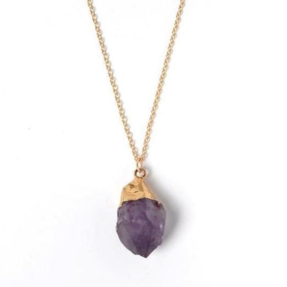 Raw amethyst pendant hanging from a fine gold-tone necklace chain.