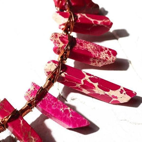 Close-up of magenta and pale stone points on the crystal tiara, showing copper wire wound around their bases.