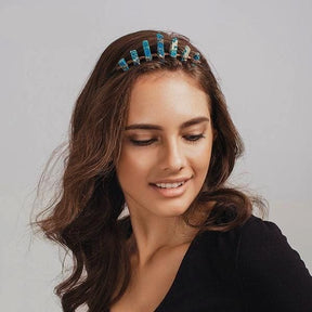 Front styling view of a turquoise crystal tiara worn above loose brown hair, with upright blue points across the crown.