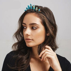 Side styling view of the turquoise crystal tiara, showing the blue points and copper wrapping above the model's hair.