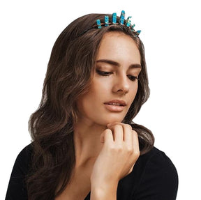 Woman wearing a turquoise-blue crystal point tiara over loose brown hair, with copper wrapping visible along the dark headband.