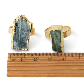 Two standing stone rings beside a ruler, with their raised settings and irregular faces visible for scale.