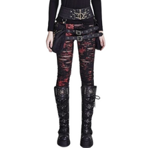 Red-and-black destroyed punk skinny pants shown from the front, with ragged horizontal openings and red markings. Styled with black belts, side bags and tall buckled boots.