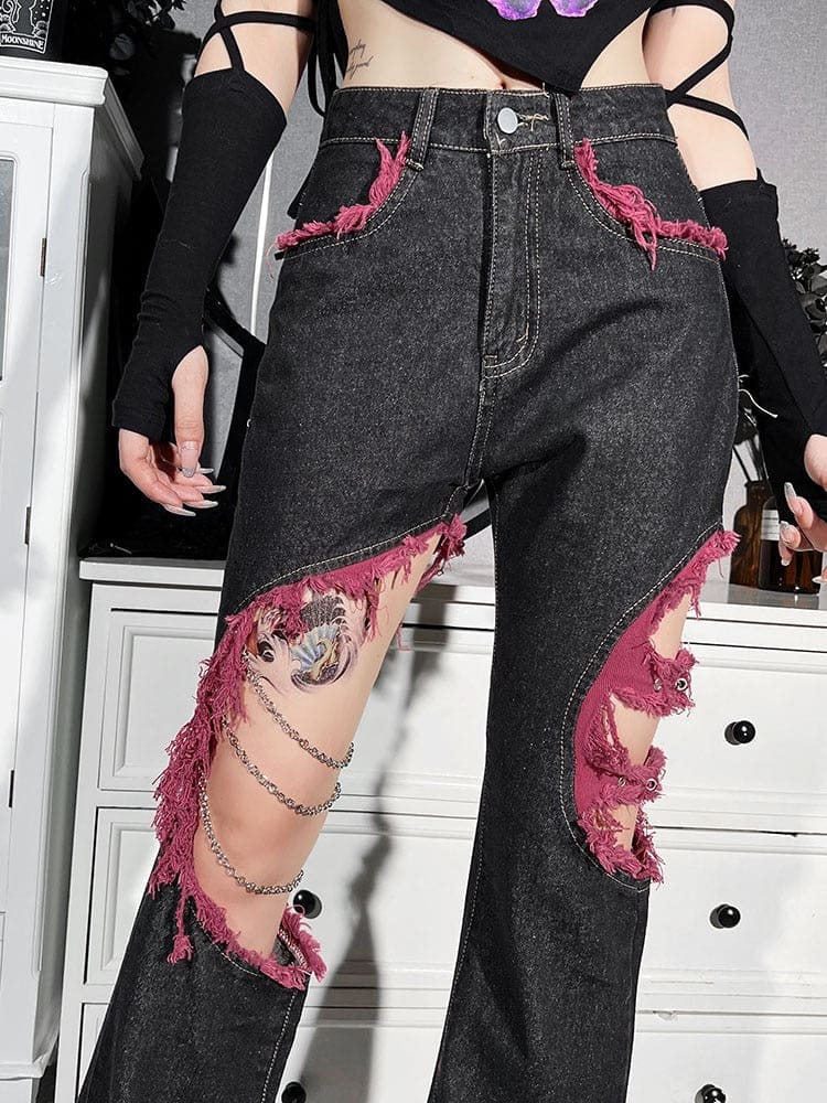 Close view of the jeans’ high waist, red-edged front pockets and asymmetric distressed openings over the thighs.