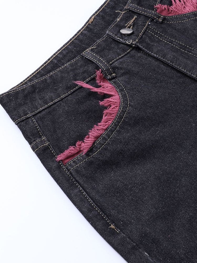 Close-up of the jeans’ front button, belt loop and pocket edge outlined with muted red frayed trim.