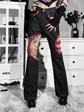 Front view of the chain-detail jeans with a hand resting at the thigh, showing the red-trimmed pocket and open knee panels.