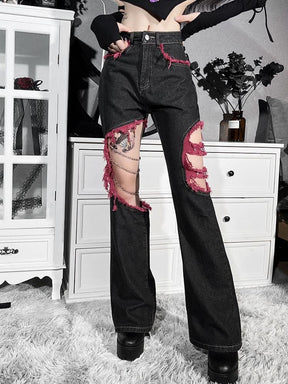 Full-length outfit view of the red-trimmed black jeans with hands at the waist, showing the flare below each open knee.