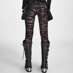 Rear view of red-and-black skinny pants showing red scratch-like markings and horizontal distressing across the seat and legs, styled with tall black boots.