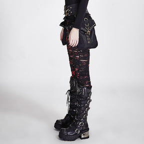 Side view of red-and-black ripped skinny pants with distressed bands down the leg, styled with a black hip bag and tall platform boots.