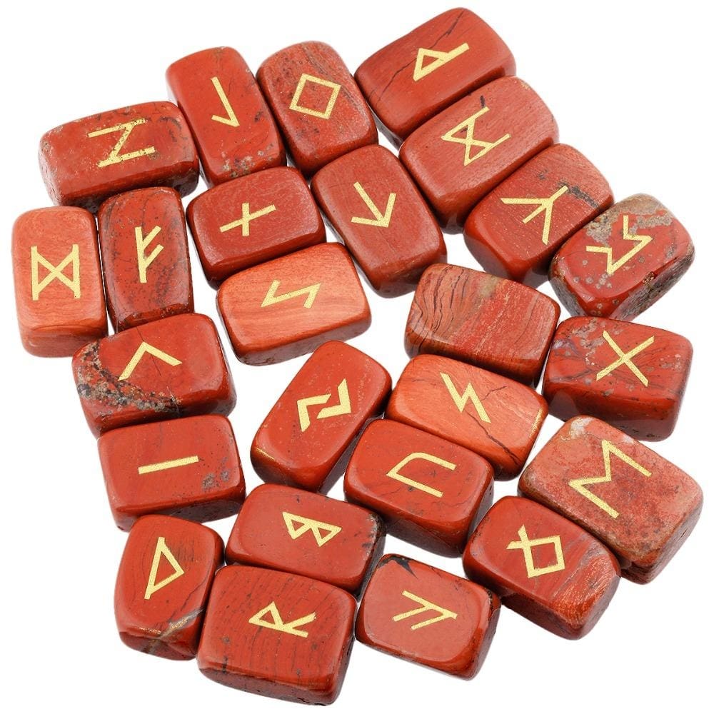 A loose pile of red jasper rune stones with brick red with darker markings surfaces, rounded edges and gold-coloured rune marks visible across the top.