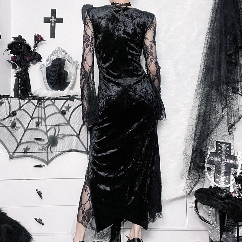 Rear view of the black velvet dress worn indoors, showing the fitted covered back and sheer lace sleeves.