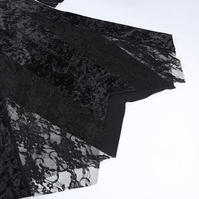 Close view of the dress's shaped lower edge, where black velvet panels meet scalloped floral lace.