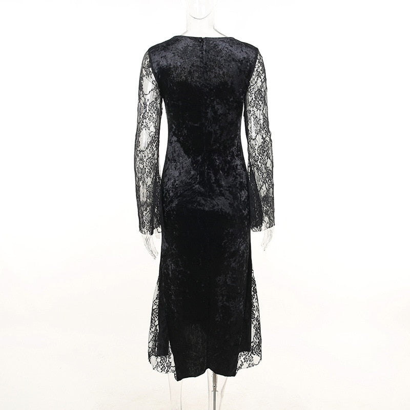 Rear view of the black velvet dress on a mannequin, showing the covered back and lace sleeves.