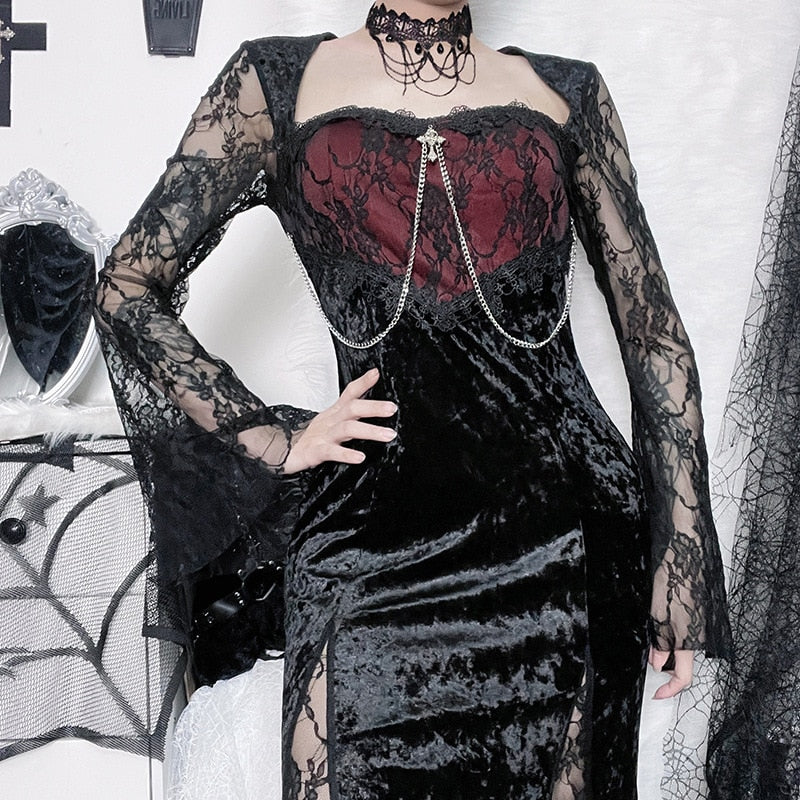 Closer front view of the black velvet dress with a hand at the waist, highlighting the red bodice and chain drapes.