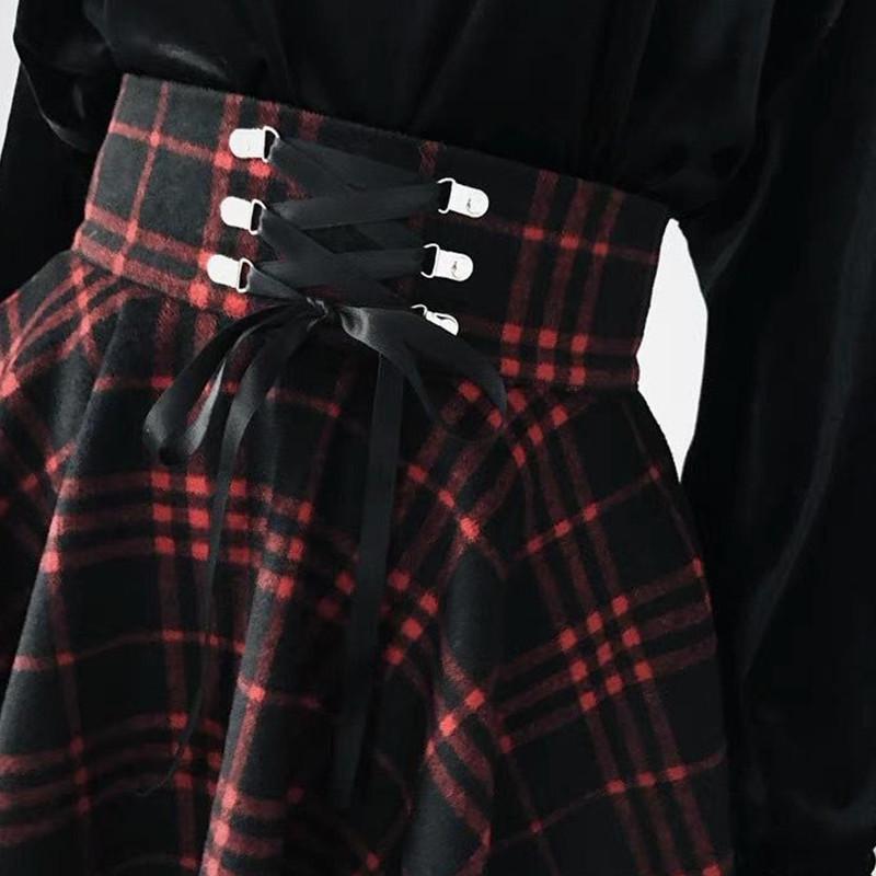 Red plaid mini skirt in a second close view of the ribbon-laced waist and flared checked fabric.