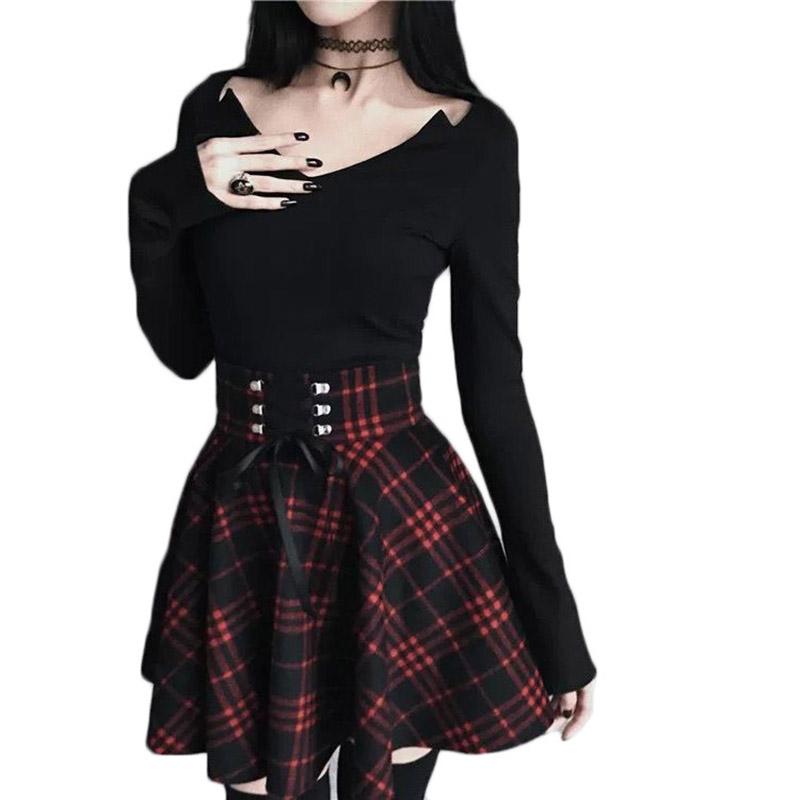 Red and black plaid mini skirt worn with a black bell-sleeve top on a white background.