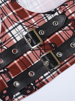 Three black buckle bands with silver-tone eyelets cross the red plaid top. The close-up shows the small skull motif in the checked fabric.