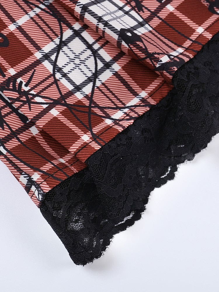 Close-up of the pleated red plaid skirt hem with a scalloped black floral lace border.