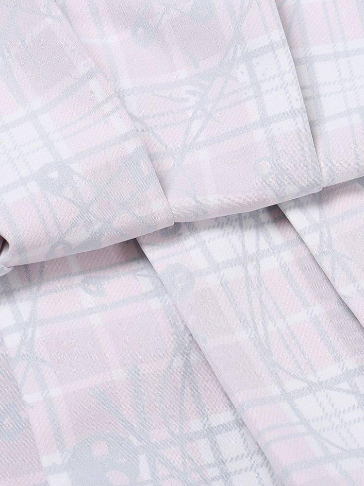 Close-up of the reverse side of the plaid fabric, showing the paler print and folded seam on the two-piece set.