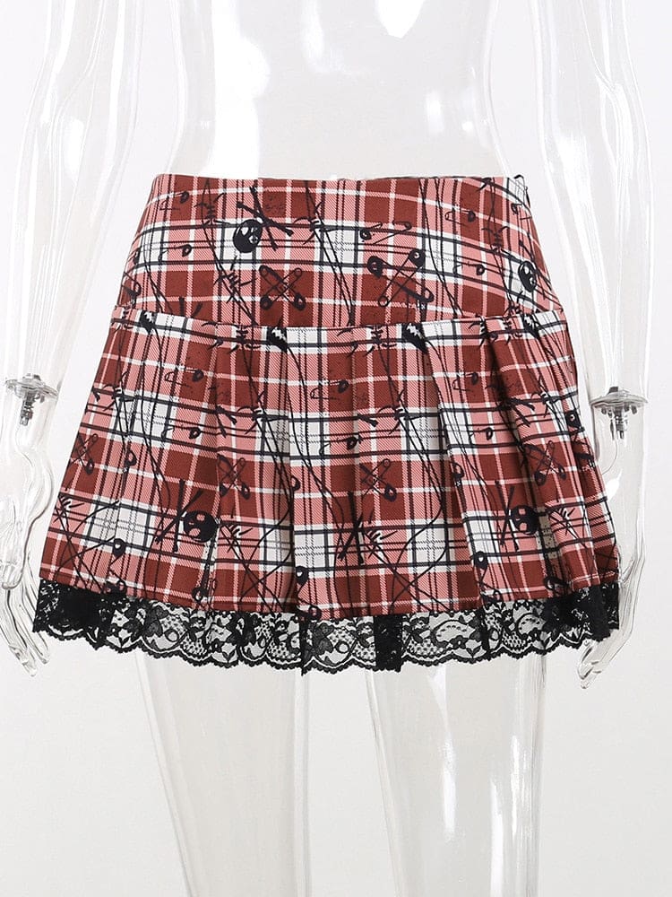 Red tartan plaid pleated mini skirt on a clear mannequin, with small black skull and safety-pin motifs and a scalloped floral lace hem.