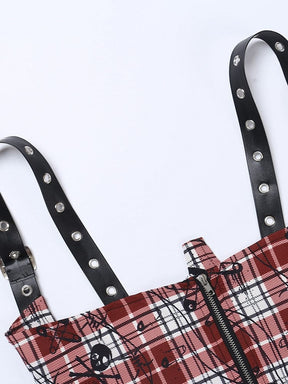 Close-up of the back zipper and shoulder straps on the red plaid cropped top, showing the black skull and safety-pin print.