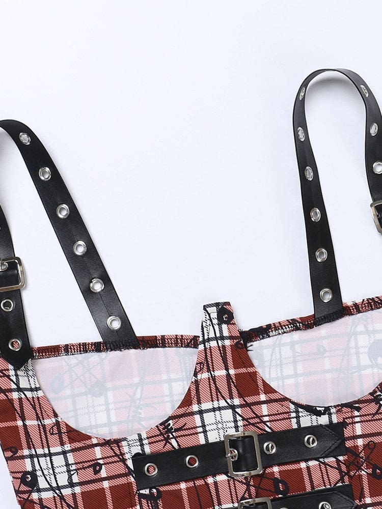 Close-up of the open-bust cutouts and black shoulder straps on the red plaid crop top. Silver-tone eyelets and the upper front buckle are visible.