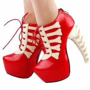 Red skeleton ankle boots worn in an angled front view, showing rounded platforms and pale spine-shaped heels.