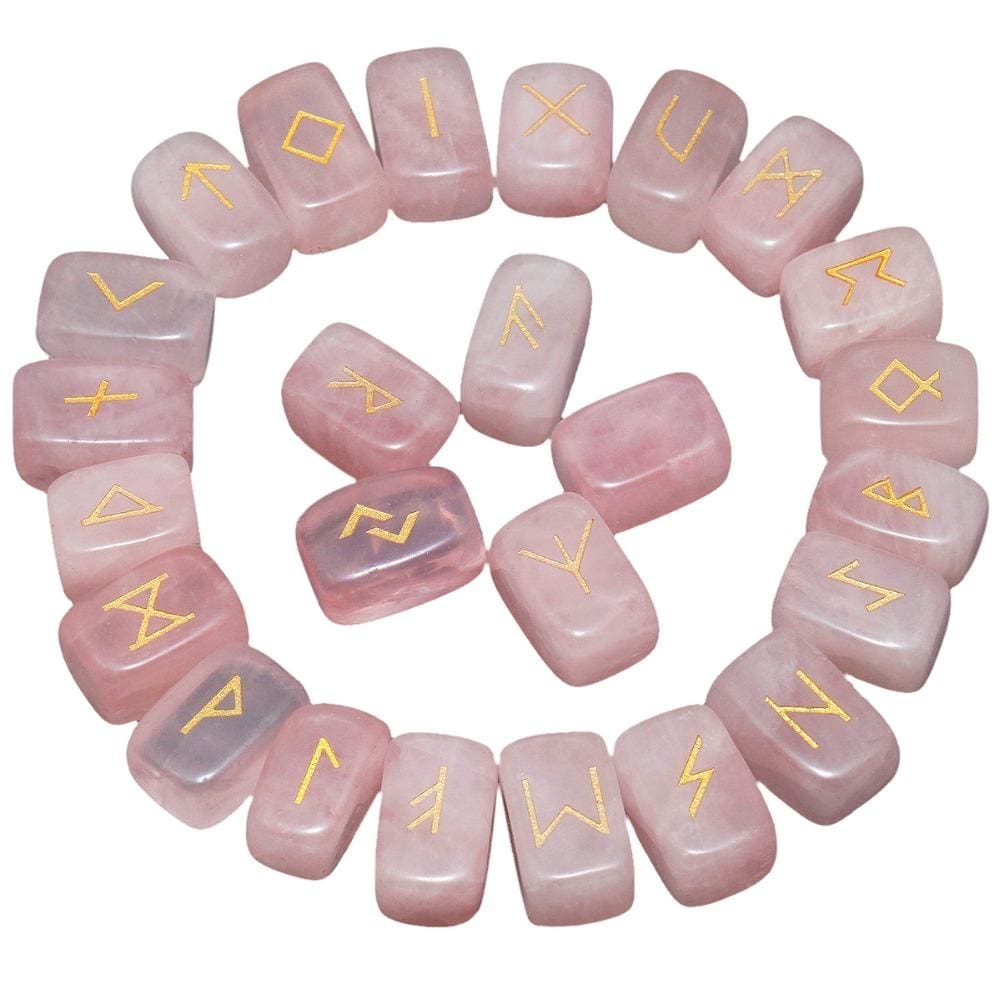 Rose quartz rune stones arranged in a circle, with pale pink polished surfaces and gold-coloured characters. The set includes a blank stone.