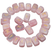 Rose quartz rune stones arranged in a circle, with pale pink polished surfaces and gold-coloured characters. The set includes a blank stone.