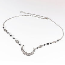 Silver-tone crescent chain headdress with small black faceted beads and narrow ornamental links, arranged in an oval on a pale background with the clasp and chain visible.