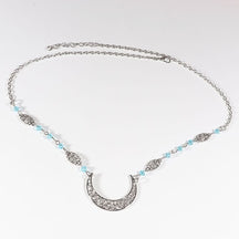 Silver-tone crescent chain headdress with small pale blue beads, arranged in an oval on a pale background with the clasp and chain visible.